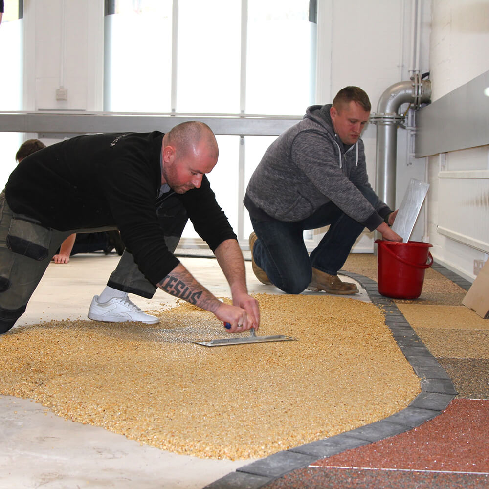 resin training course 2 men laying gravel